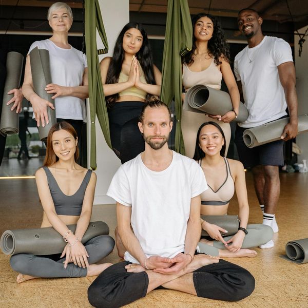 Diverse group of people of different ages smiling during a yoga class.
