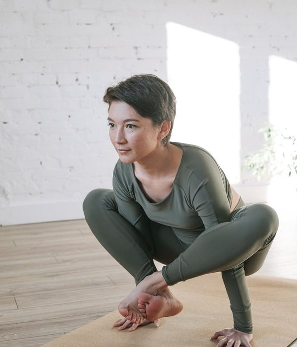 Woman holding a serene yoga pose in a bright, peaceful room.